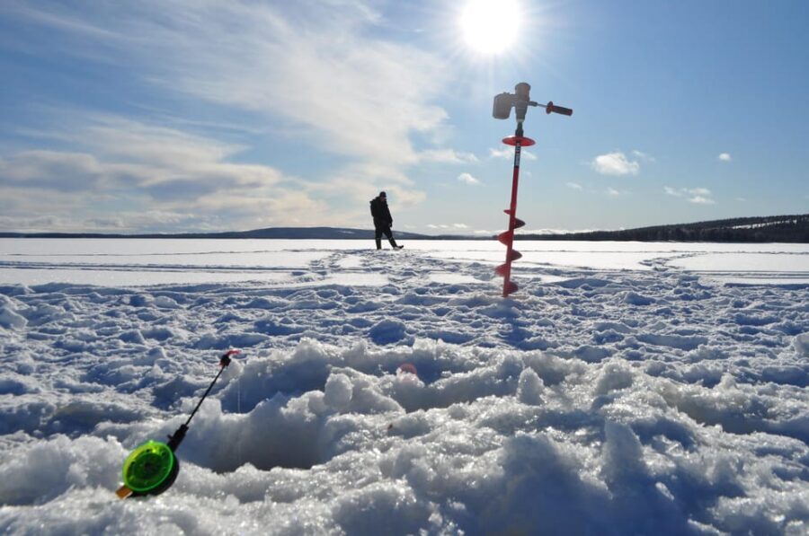 Ice fishing program in Lapland - The frozen-lake moment: making the hole and starting to fish